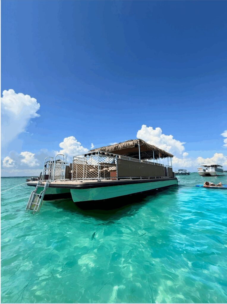 Gilligan’s tiki boat on the clear turquoise water off Destin, Florida